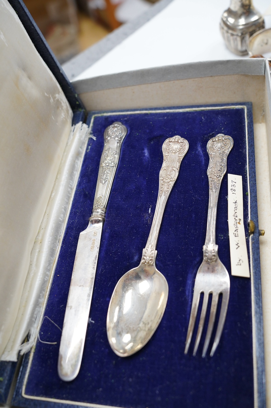 Small silver to include a cased Victorian silver Queens pattern christening trio, London 1837, four various silver napkin rings, a plated napkin ring, two condiments and a silver mounted wooden 'milk churn' pepper mill.